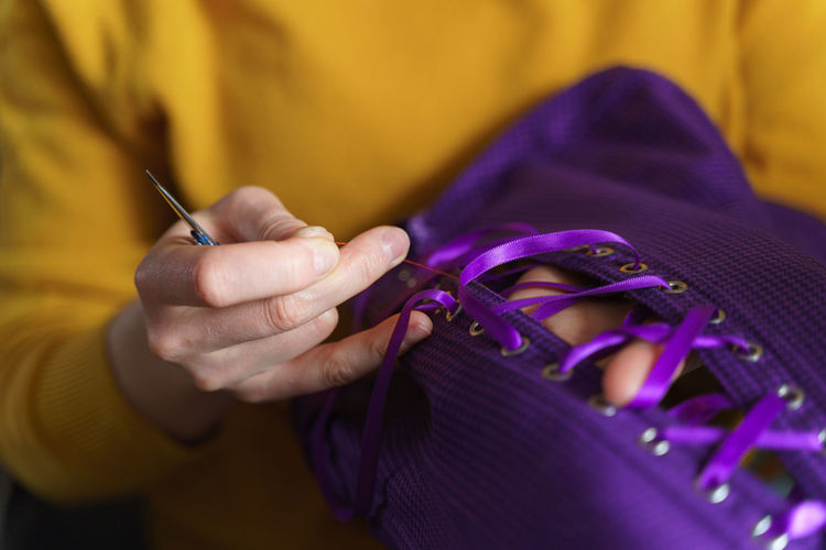 Close-up of hand holding purple flower