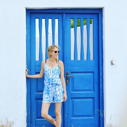 Girl standing against blue door