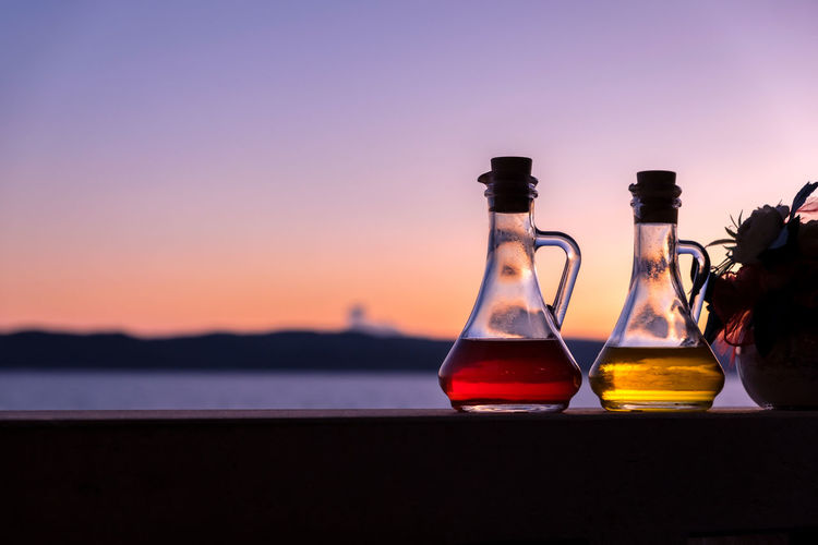 Close-up of oil and vinegar bottle in restaurant at sunset