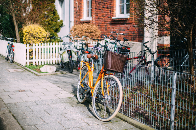 Bicycle leaning on fence against building