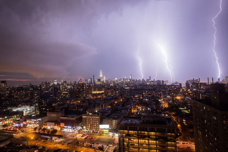 Lightning over illuminated cityscape at night