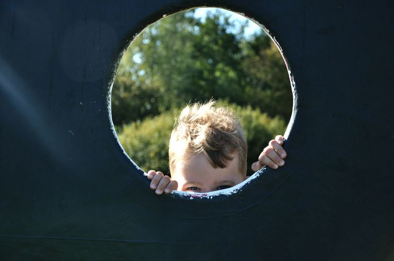 Boy seen through play equipment