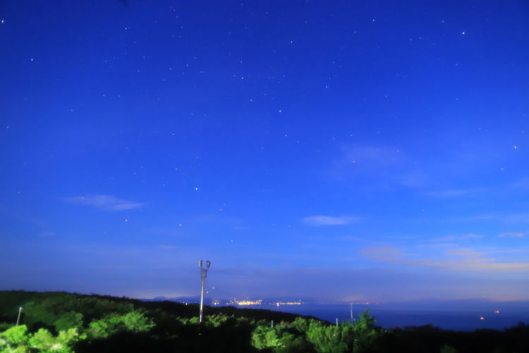 Scenic view of landscape against blue sky at night