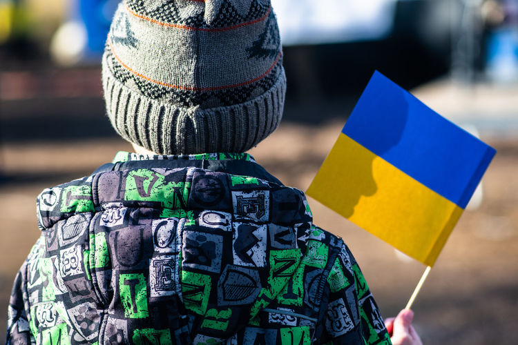 Child during a peaceful demonstration against war, putin and russia in support of ukraine, with flag