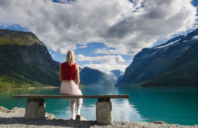 Woman looking at lake against mountains