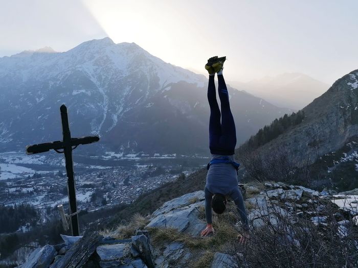 Man standing on snow covered mountain against sky
