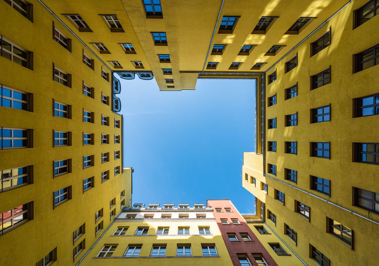 Directly below shot of residential buildings against blue sky