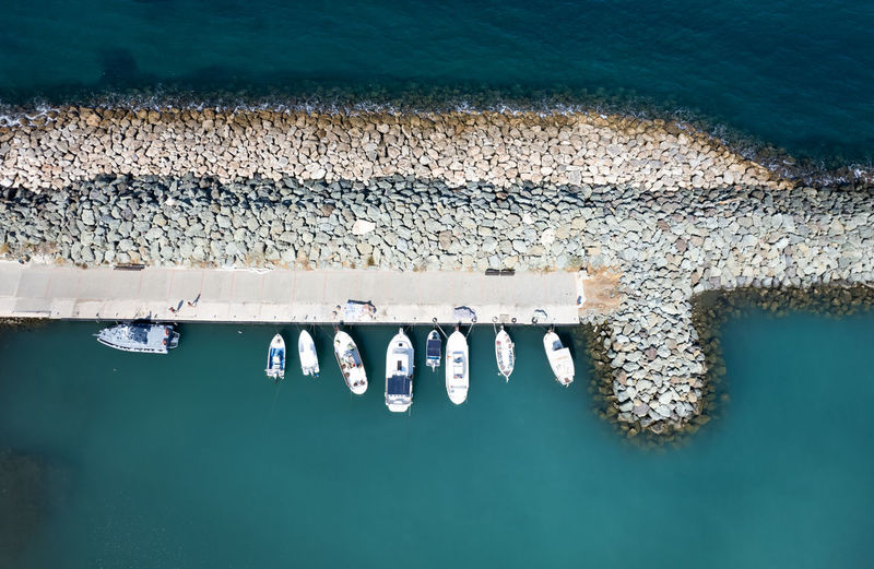 Aerial drone view of fishing boats moored at the harbor. moored at breakwater.