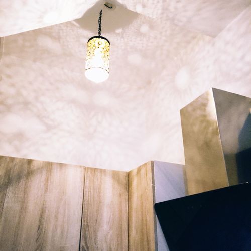 Low angle view of illuminated pendant light hanging on ceiling