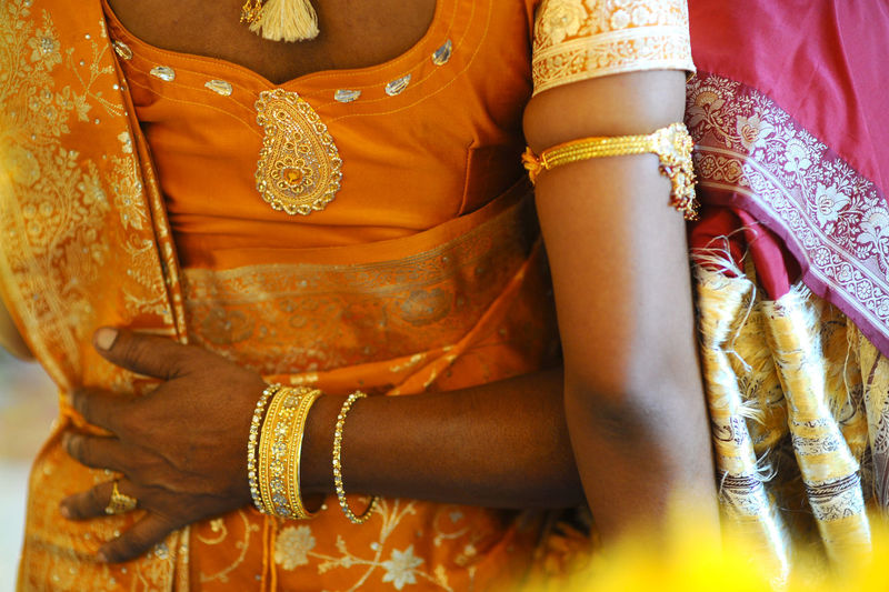 Midsection of woman with bride during wedding ceremony