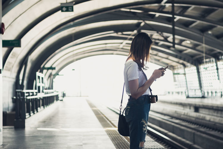 Woman standing on railroad station platform