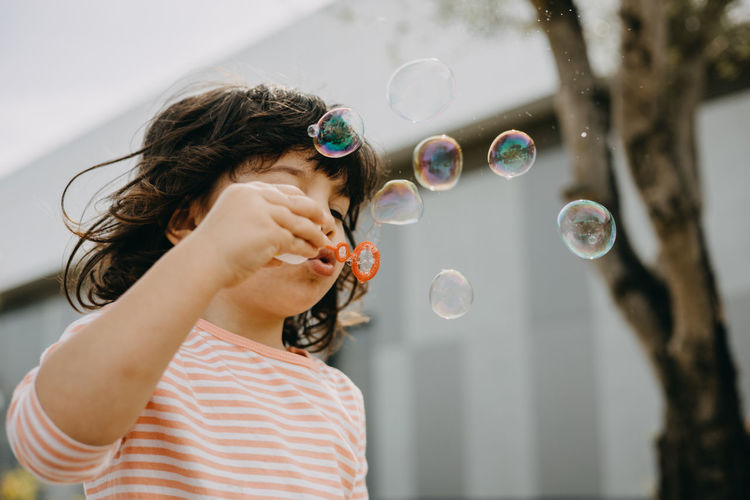 MIDSECTION OF WOMAN HOLDING BUBBLES WITH BUBBLE