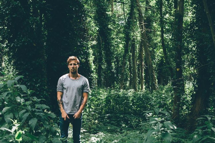 Young man standing in forest