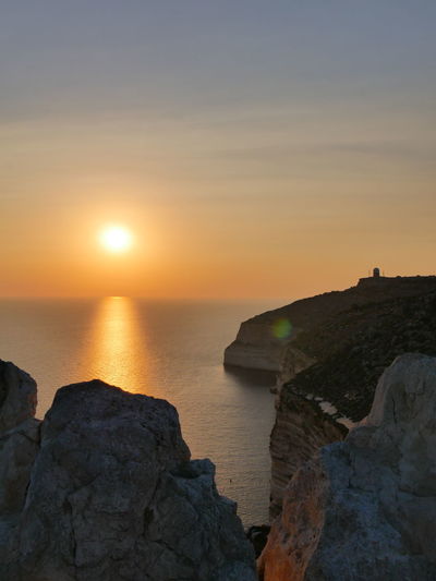 Sun hiding behind xaqqa cliffs in malta