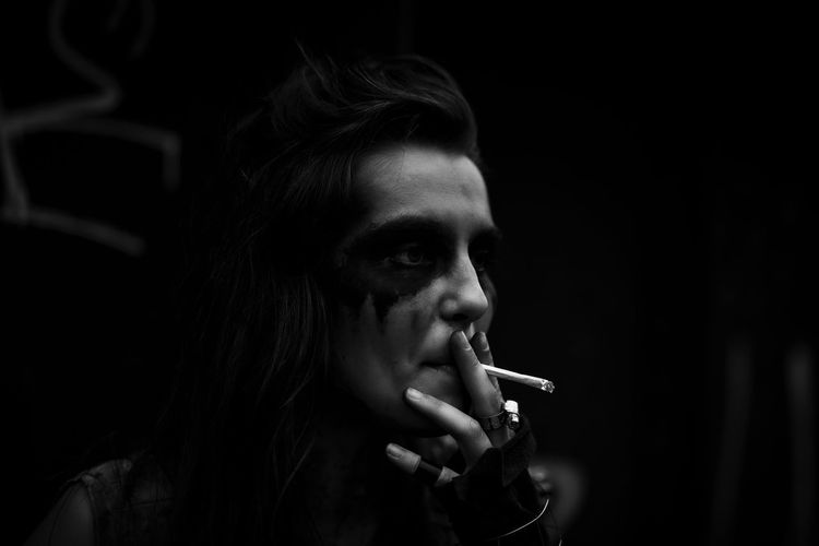 Punk woman smoking cigarette outdoors
