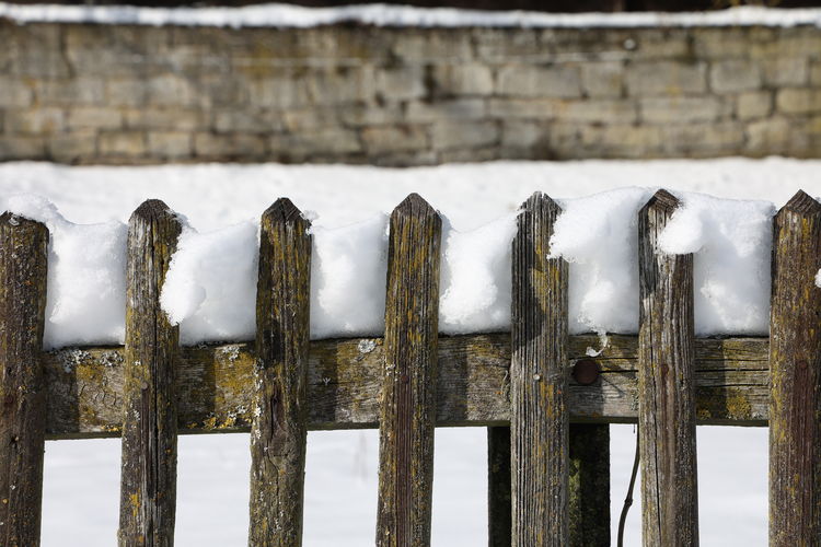 Panoramic shot of wooden fence on snow covered landscape