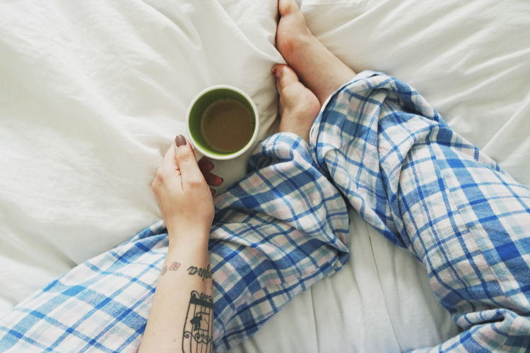 Woman relaxing in bed with tea