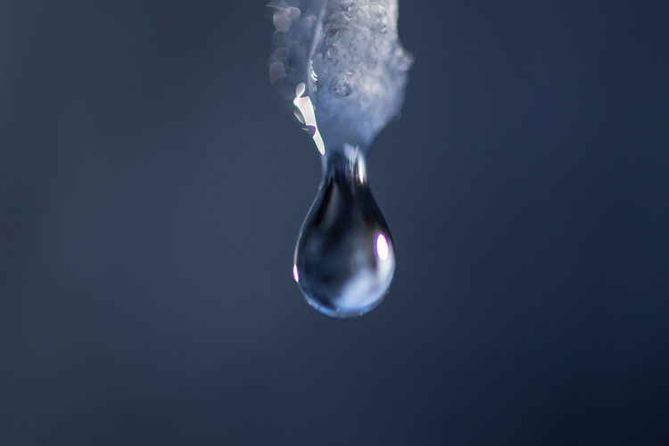 Close-up of water drop against gray background