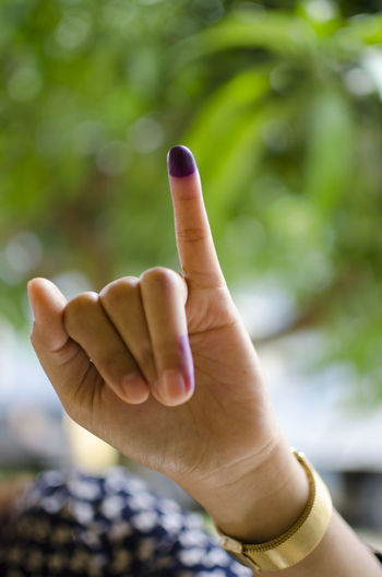 Cropped hand of woman showing inked finger