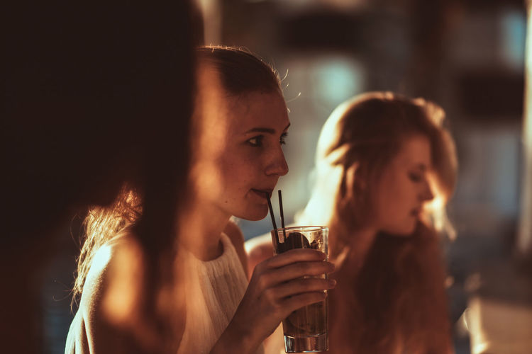Close-up of young woman with drink at restaurant