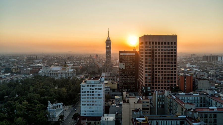 Torre latinoamericana amidst cityscape against sky during sunrise
