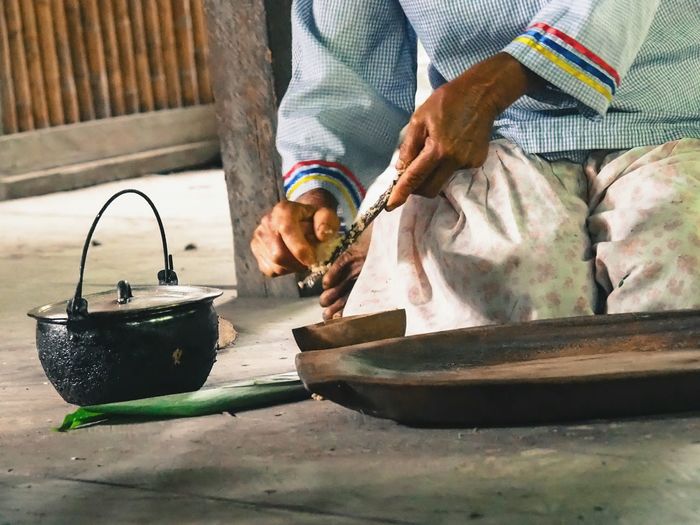 Midsection of woman preparing food while kneeling on floor