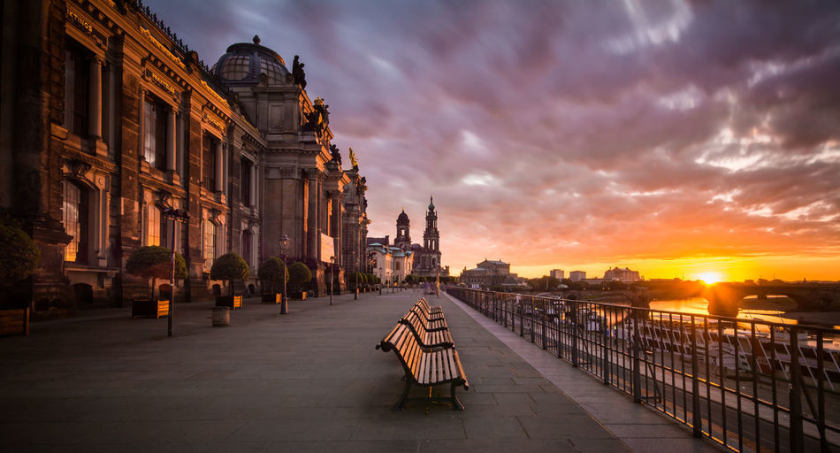 Empty benches by dresden frauenkirche in city during sunset