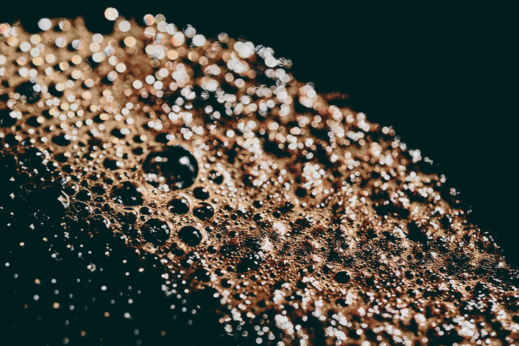 Close-up of coffee over water against black background