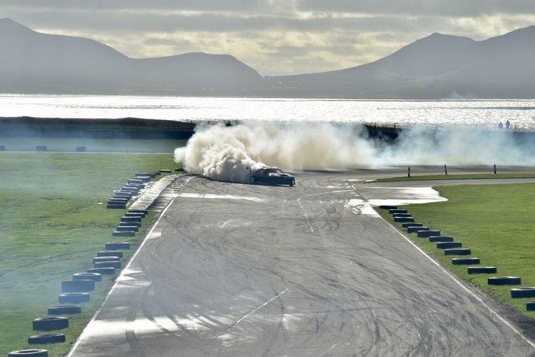 View of a drift car at anglesey race circuit with sea and mountains in the background 