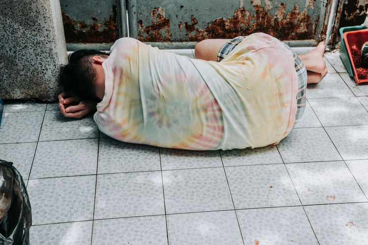 Homeless man sleeps on the street , bangkok thailand.