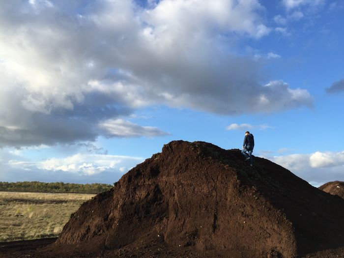 Low angle view of a man on paet rock against sky