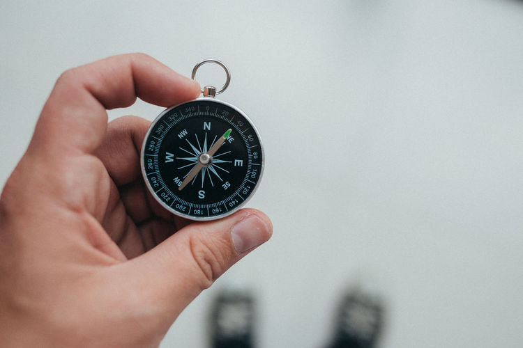 Cropped hand of person holding navigational compass