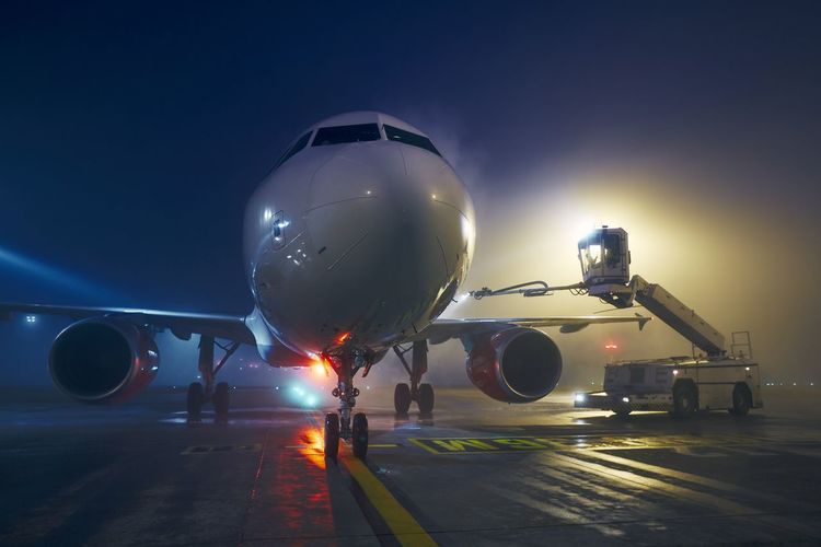Winter frosty night at airport. deicing of airplane before flight.