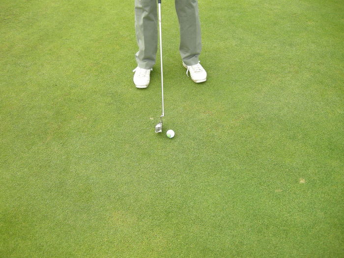 Low section of man standing on golf course