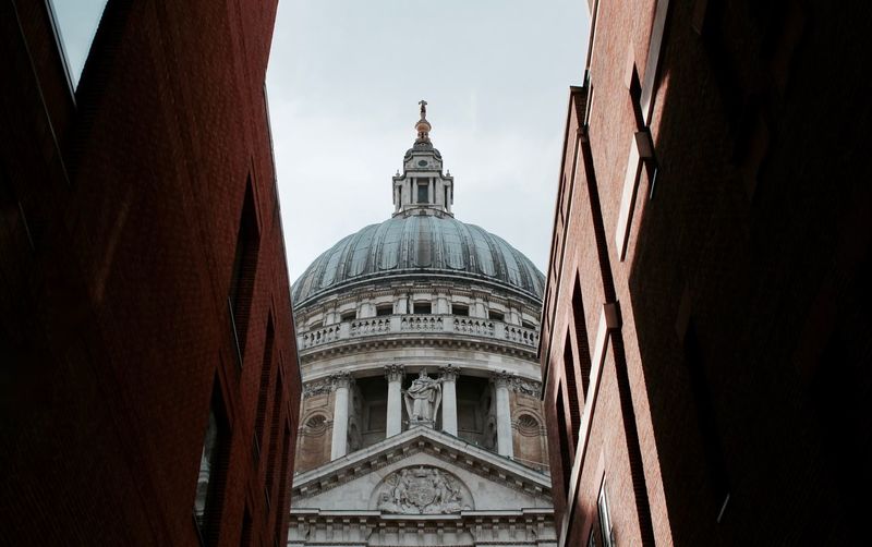 Low angle view of st pauls cathedral and buildings against sky