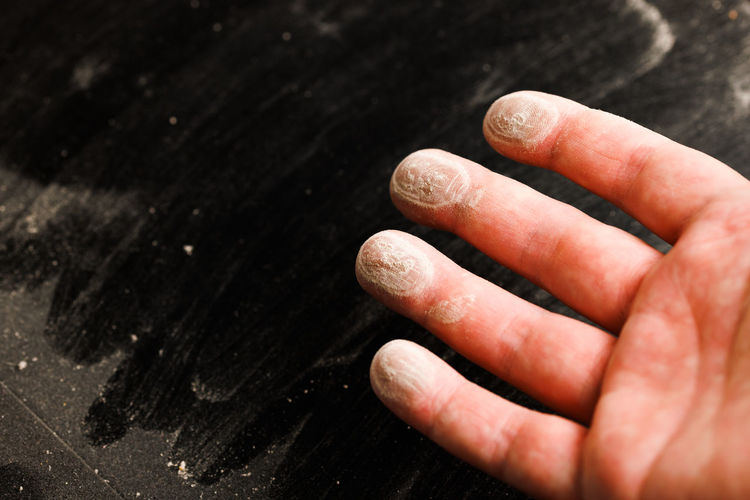 Caucasian hand with dust on finger tips after touching black dusty surface