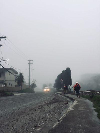 People walking on street in foggy weather