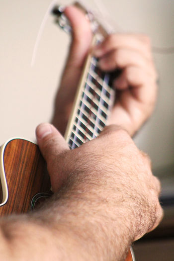 Cropped hands playing ukulele