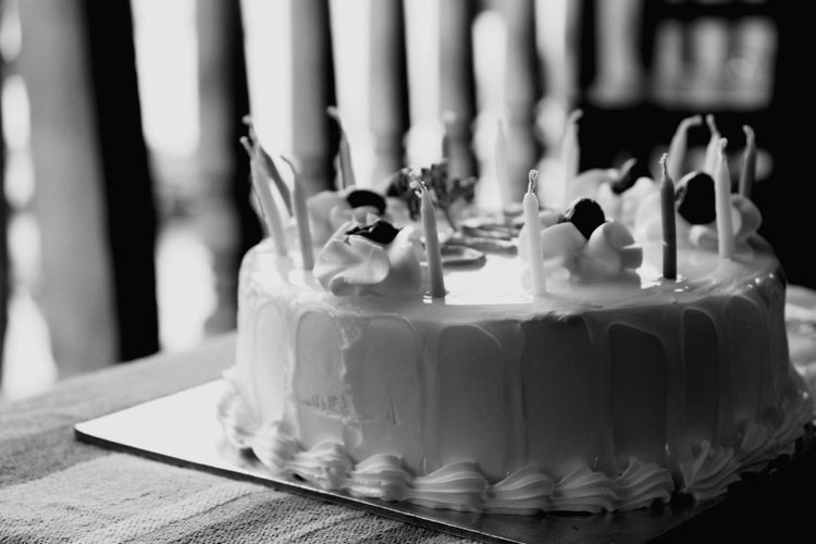 Close-up of birthday cake with candles on table