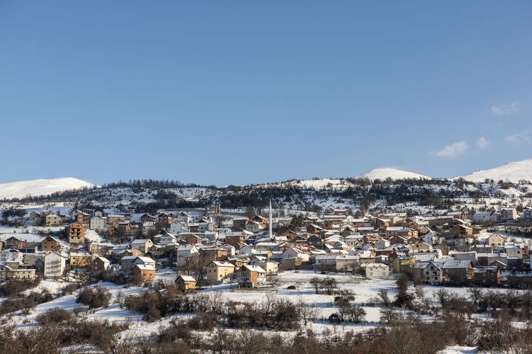Buildings in town against clear blue sky