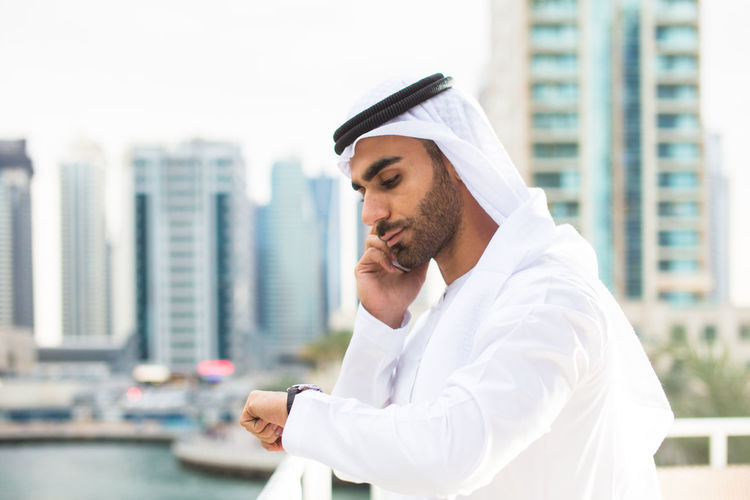Young man wearing traditional clothing talking over smart phone