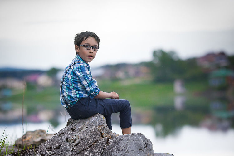 Young man sitting on rock