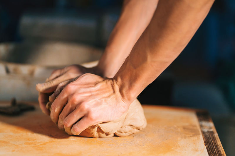 Cropped hands kneading dough