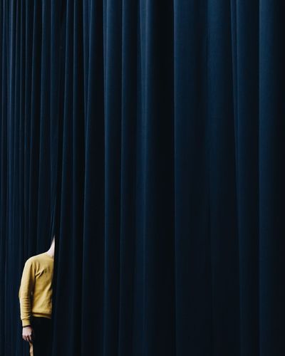 Man standing by blue curtain