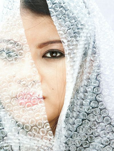 Close-up portrait of young woman wearing bubble wrap
