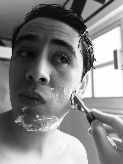 Close-up of young man shaving