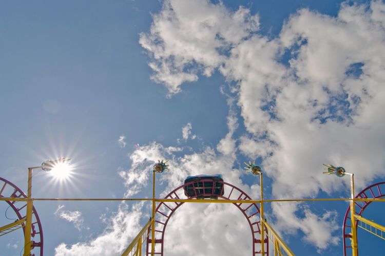 Low angle view of a rollercoaster against cloudy sky