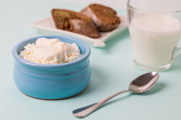 Cottage cheese in a blue bowl with sour cream and honey.