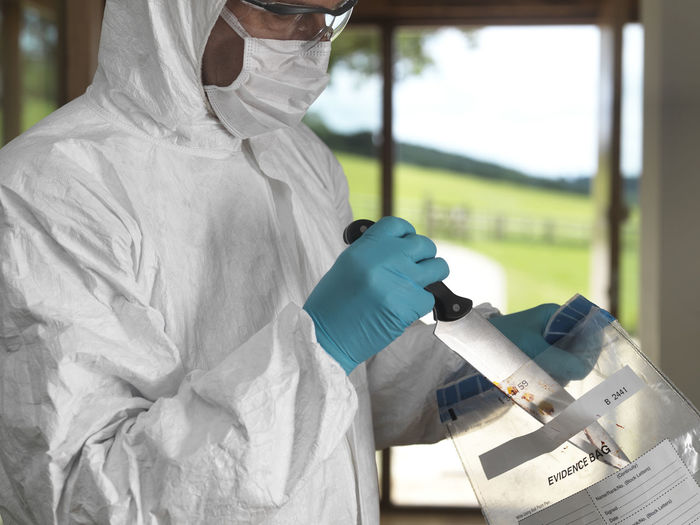 Forensic scientist bagging a knife taken from a violent crime scene