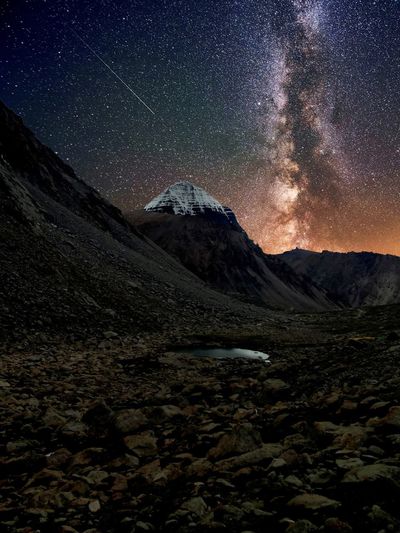 SCENIC VIEW OF SNOWCAPPED MOUNTAINS AGAINST STAR FIELD AT NIGHT